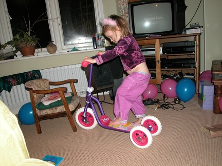 Grace playing with her new scooter. Maybe someone should have bought a belt for her birthday. And braces.