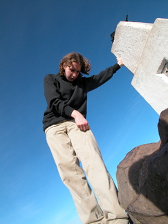 Rob leaning on a trig point
